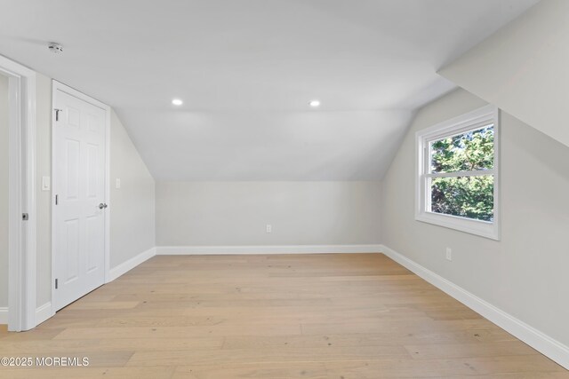 additional living space with recessed lighting, light wood-style flooring, baseboards, and vaulted ceiling