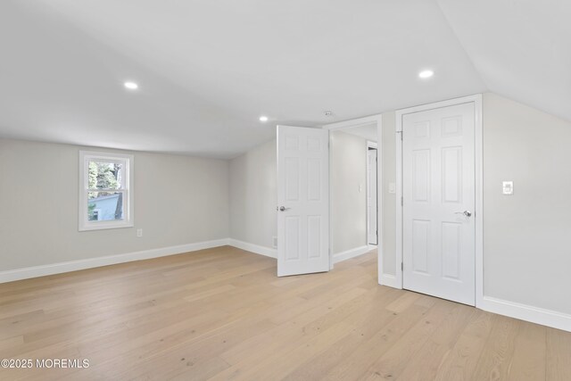 interior space with recessed lighting, baseboards, light wood-style flooring, and vaulted ceiling