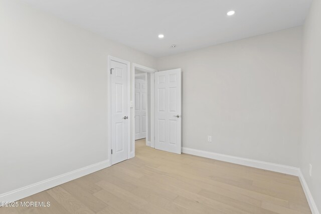 empty room with recessed lighting, baseboards, and light wood-style floors