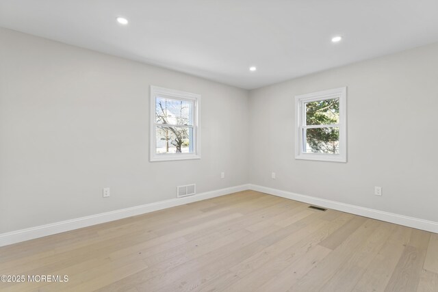 spare room featuring recessed lighting, visible vents, plenty of natural light, and light wood finished floors