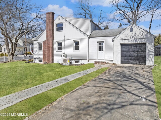 view of side of property featuring a lawn, entry steps, fence, an attached garage, and a chimney