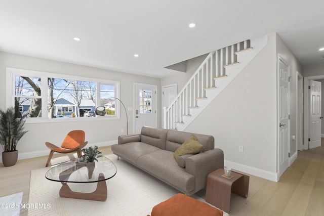 living area with light wood-type flooring, stairway, baseboards, and recessed lighting