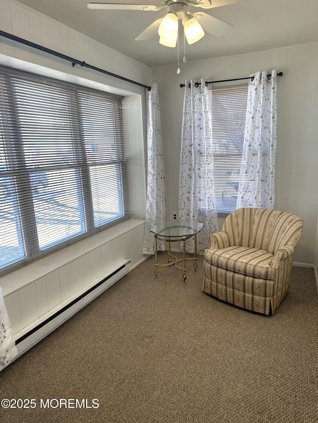 sitting room with baseboard heating, ceiling fan, and carpet floors