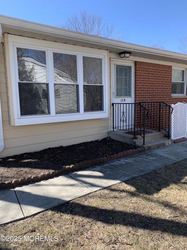 doorway to property with brick siding