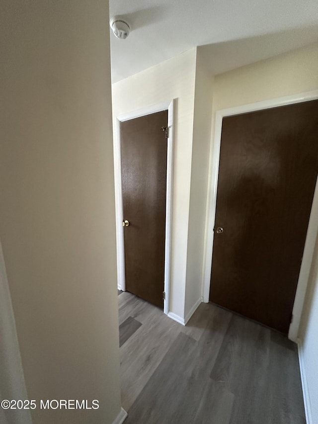 hallway featuring baseboards and wood finished floors