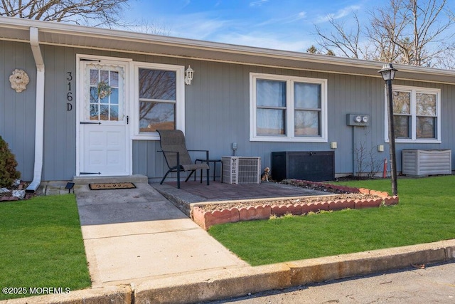 property entrance with a yard and central AC