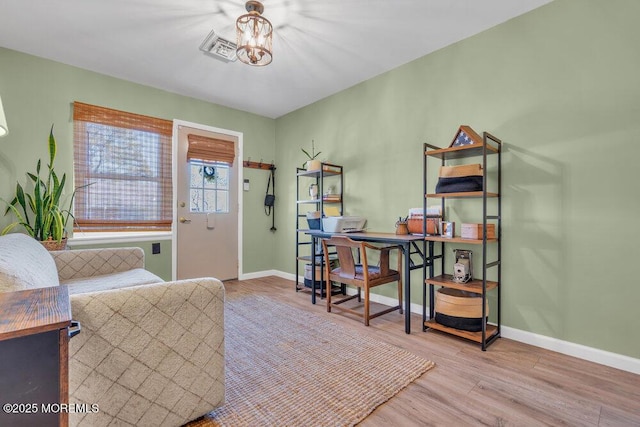 interior space with an inviting chandelier, visible vents, wood finished floors, and baseboards