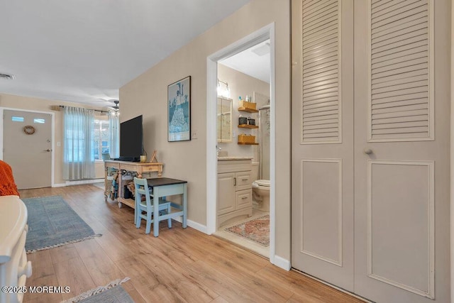 corridor featuring light wood-style floors, visible vents, and baseboards