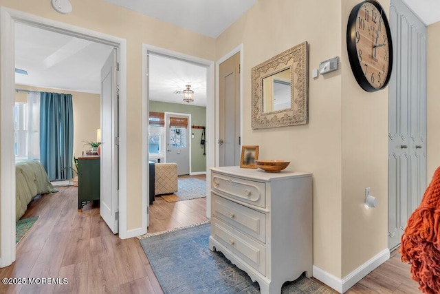 hall with baseboards and light wood finished floors