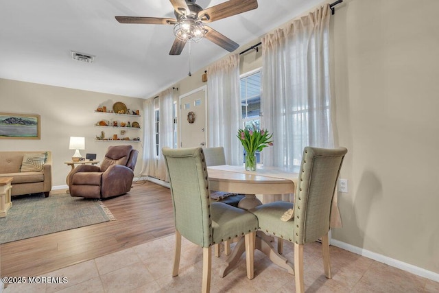 dining space featuring light tile patterned floors, visible vents, baseboards, and a ceiling fan