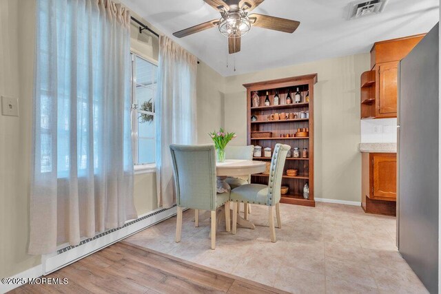 dining area with visible vents, ceiling fan, baseboards, and a baseboard radiator