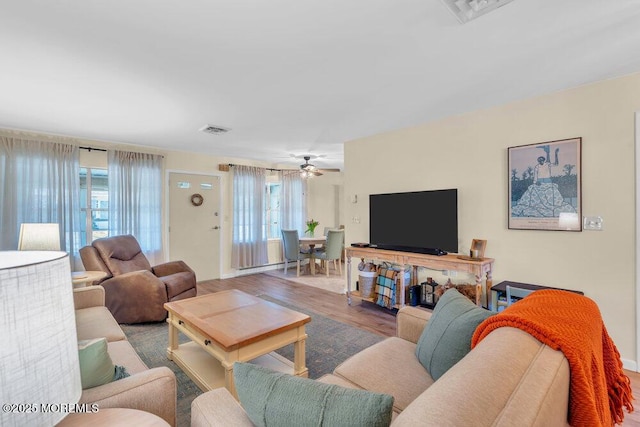 living area with visible vents, plenty of natural light, and wood finished floors