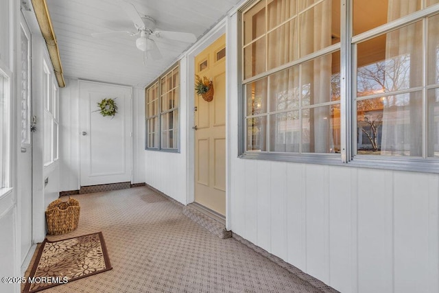 unfurnished sunroom with ceiling fan