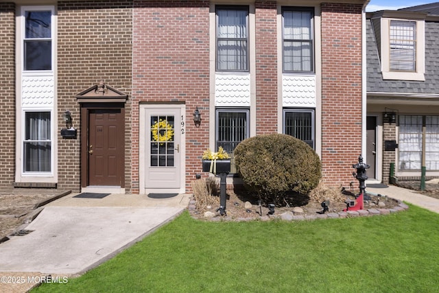 view of exterior entry featuring brick siding