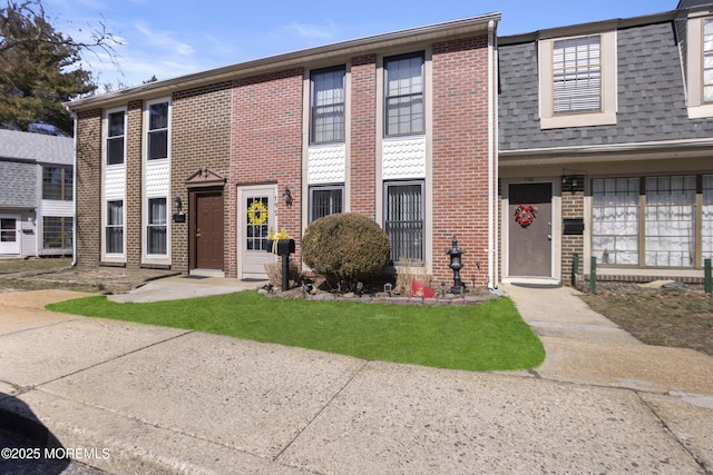 multi unit property with brick siding and roof with shingles