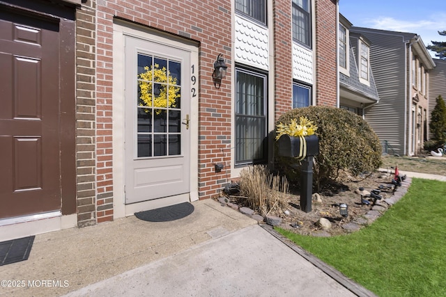 doorway to property featuring brick siding