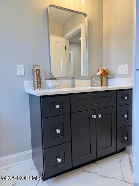 bathroom with vanity, baseboards, and marble finish floor