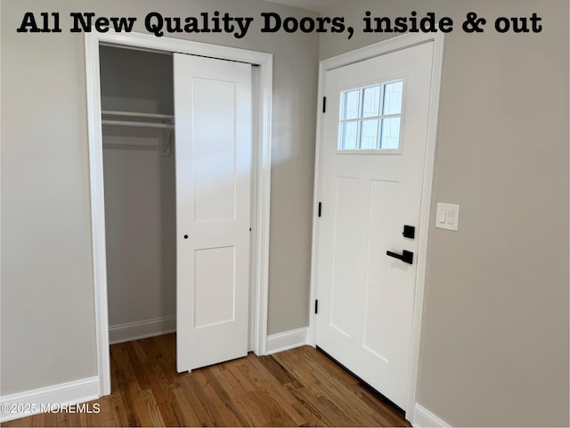 foyer entrance featuring dark wood-type flooring and baseboards