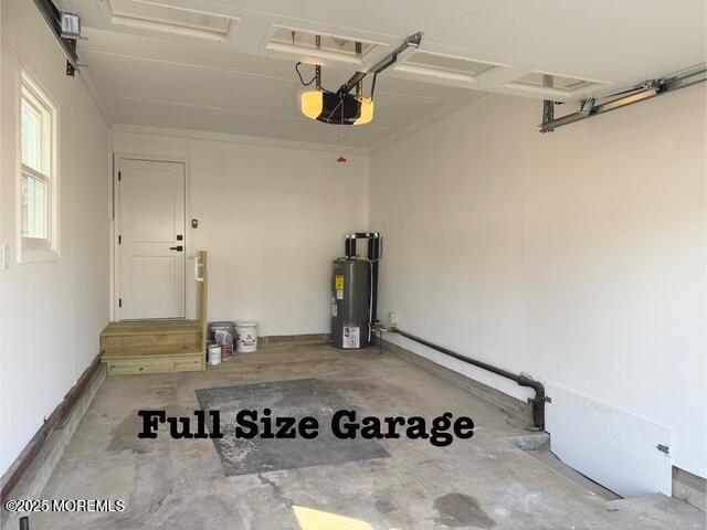 garage featuring water heater and a garage door opener