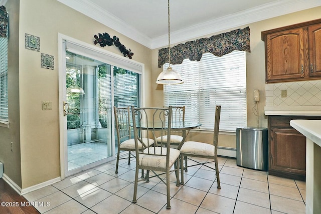dining room featuring light tile patterned floors, a baseboard heating unit, baseboards, and ornamental molding