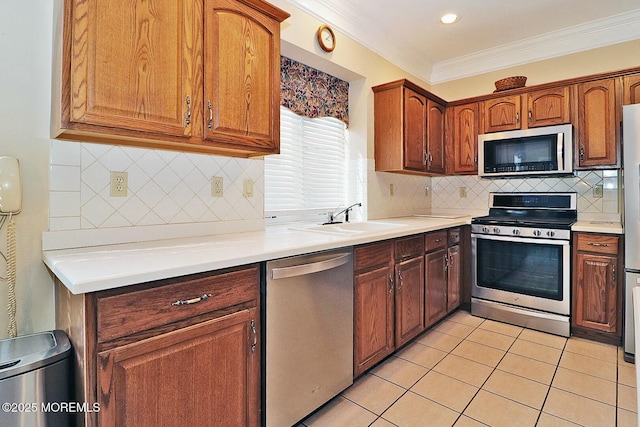 kitchen with light tile patterned flooring, a sink, ornamental molding, light countertops, and stainless steel appliances
