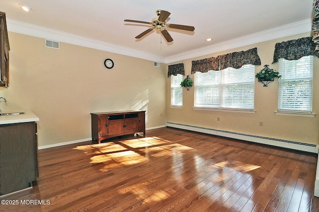 living room featuring hardwood / wood-style floors, baseboards, visible vents, a baseboard heating unit, and crown molding