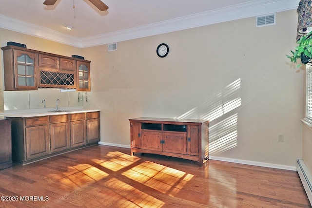 bar featuring a sink, visible vents, baseboard heating, and indoor wet bar