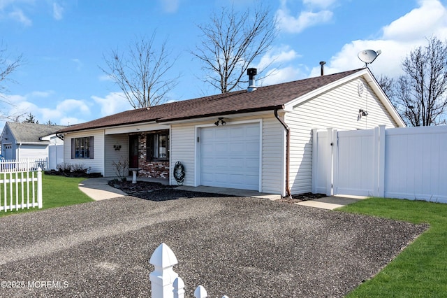 ranch-style house featuring fence, aphalt driveway, a front yard, an attached garage, and a gate