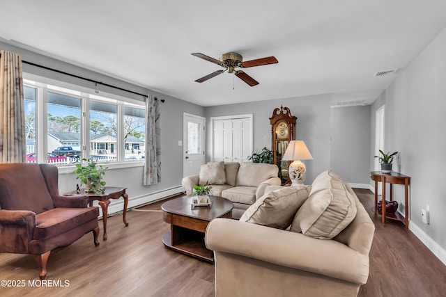 living area with wood finished floors, baseboards, visible vents, ceiling fan, and a baseboard heating unit