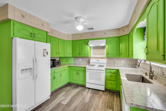 kitchen with white appliances, ventilation hood, a ceiling fan, visible vents, and a sink