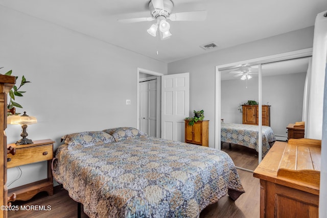 bedroom with wood finished floors, visible vents, a closet, and ceiling fan