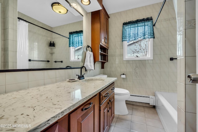 bathroom with tile patterned flooring, a baseboard heating unit, tile walls, toilet, and a wealth of natural light