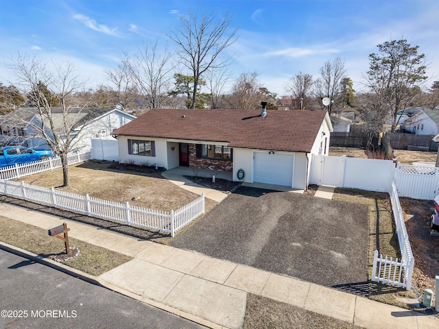 single story home featuring a fenced front yard, driveway, a garage, and a gate