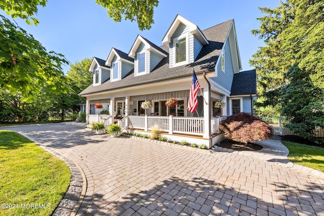 cape cod home with covered porch and a shingled roof