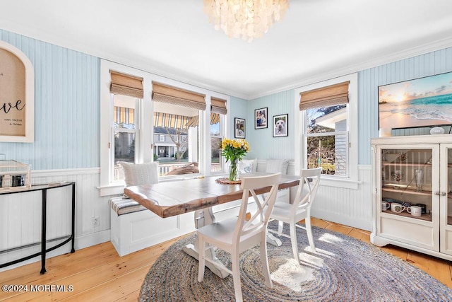 dining space featuring a wainscoted wall and light wood-style flooring