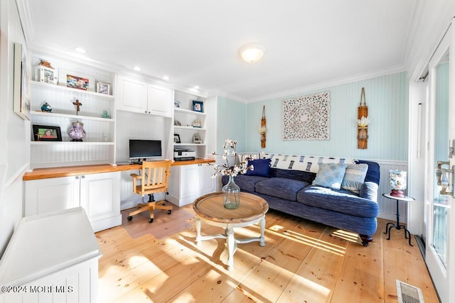 living area with visible vents, crown molding, and built in study area