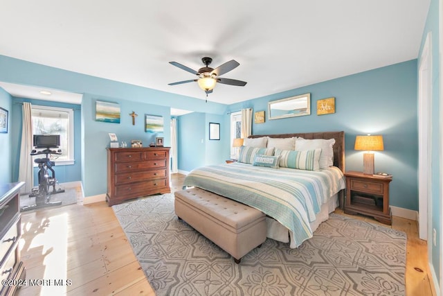 bedroom with baseboards, a ceiling fan, and light wood finished floors