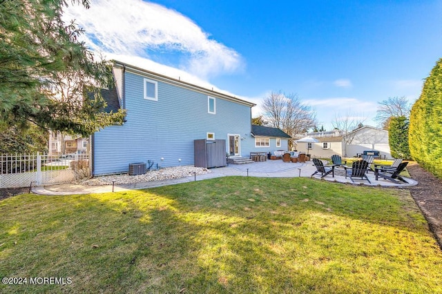 back of house with fence, entry steps, central AC unit, a lawn, and a patio area