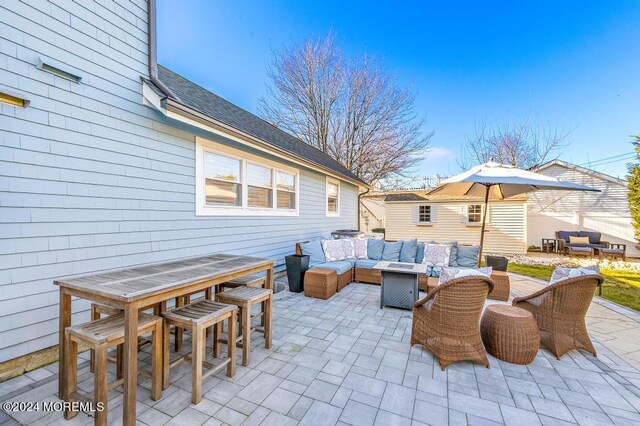 view of patio with outdoor dining area, an outdoor hangout area, and an outbuilding