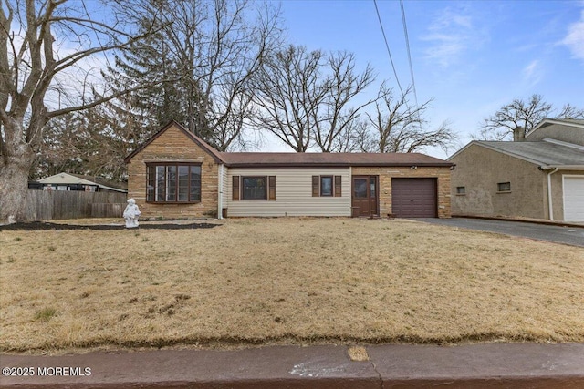 ranch-style home with aphalt driveway, stone siding, an attached garage, and fence