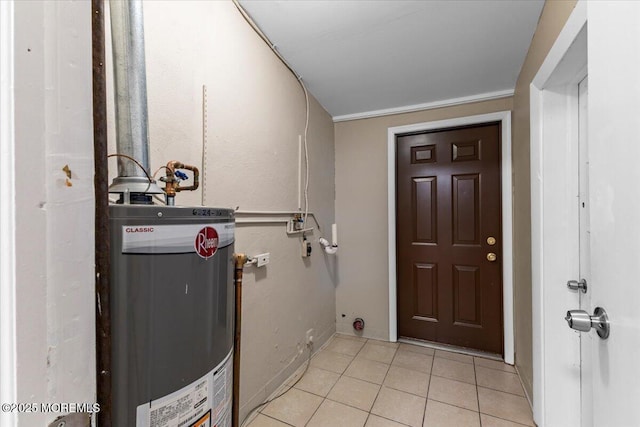 washroom featuring gas water heater, light tile patterned floors, and laundry area