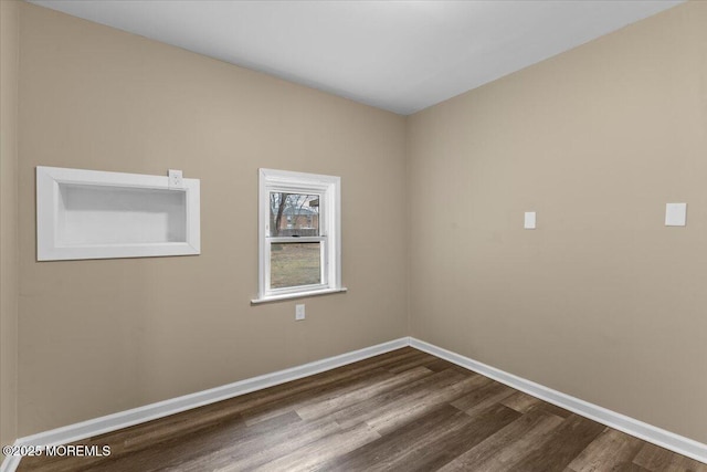 unfurnished room featuring baseboards and dark wood-style flooring