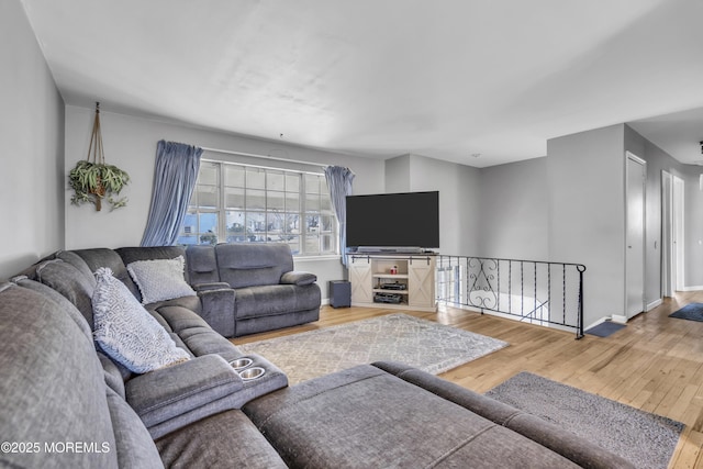 living area featuring baseboards and hardwood / wood-style flooring