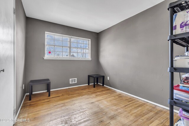 bedroom with visible vents, baseboards, and hardwood / wood-style flooring