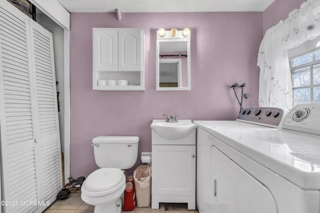 bathroom with washer and clothes dryer, toilet, vanity, and a closet