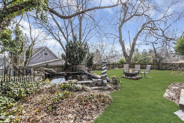 view of yard featuring a fire pit and a fenced backyard