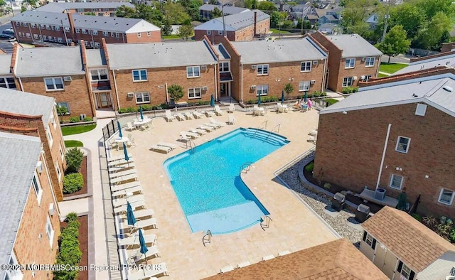 pool with a residential view, fence, and a patio area