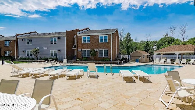 pool with a patio and fence