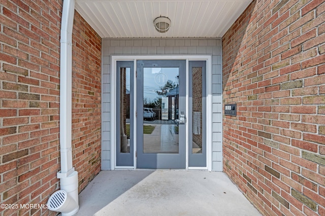 doorway to property featuring brick siding