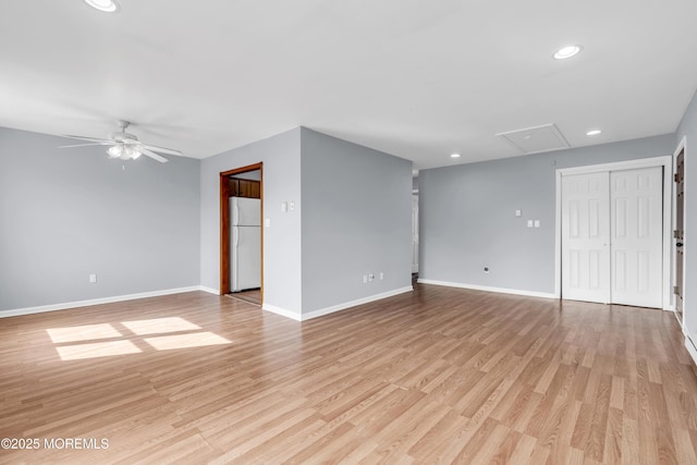 empty room featuring recessed lighting, light wood finished floors, baseboards, attic access, and ceiling fan